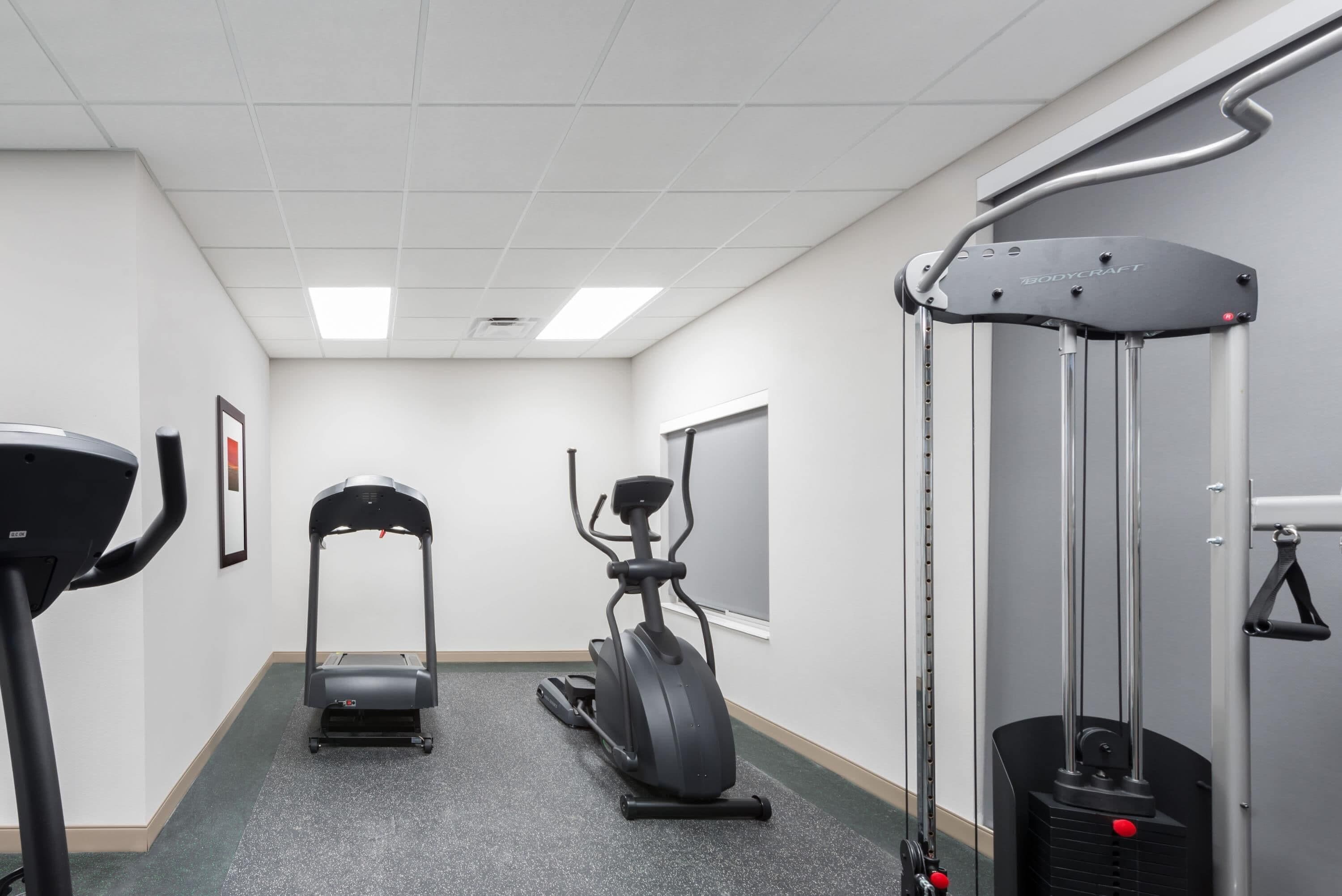 A gym with treadmills, an elliptical, and a cable machine.