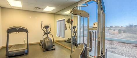 A gym with treadmills, an elliptical, and a weight machine.