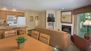 A compact living space with a kitchenette, dining area, and a fireplace.