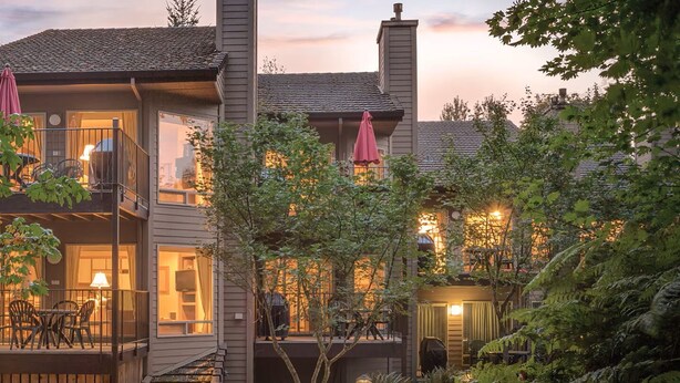 A two-story building with a balcony and outdoor seating area.