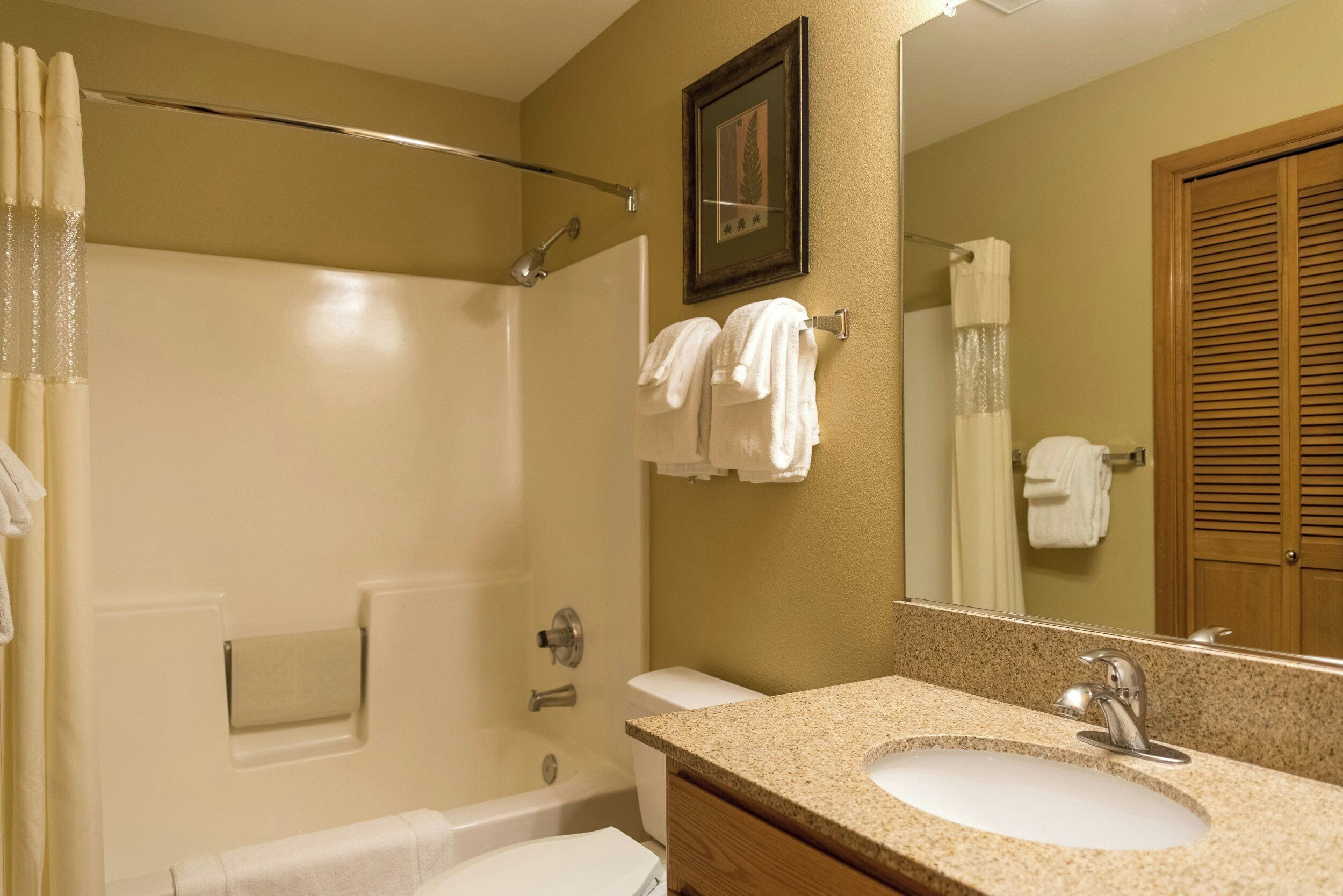 Une salle de bain avec une baignoire, un lavabo et un miroir.