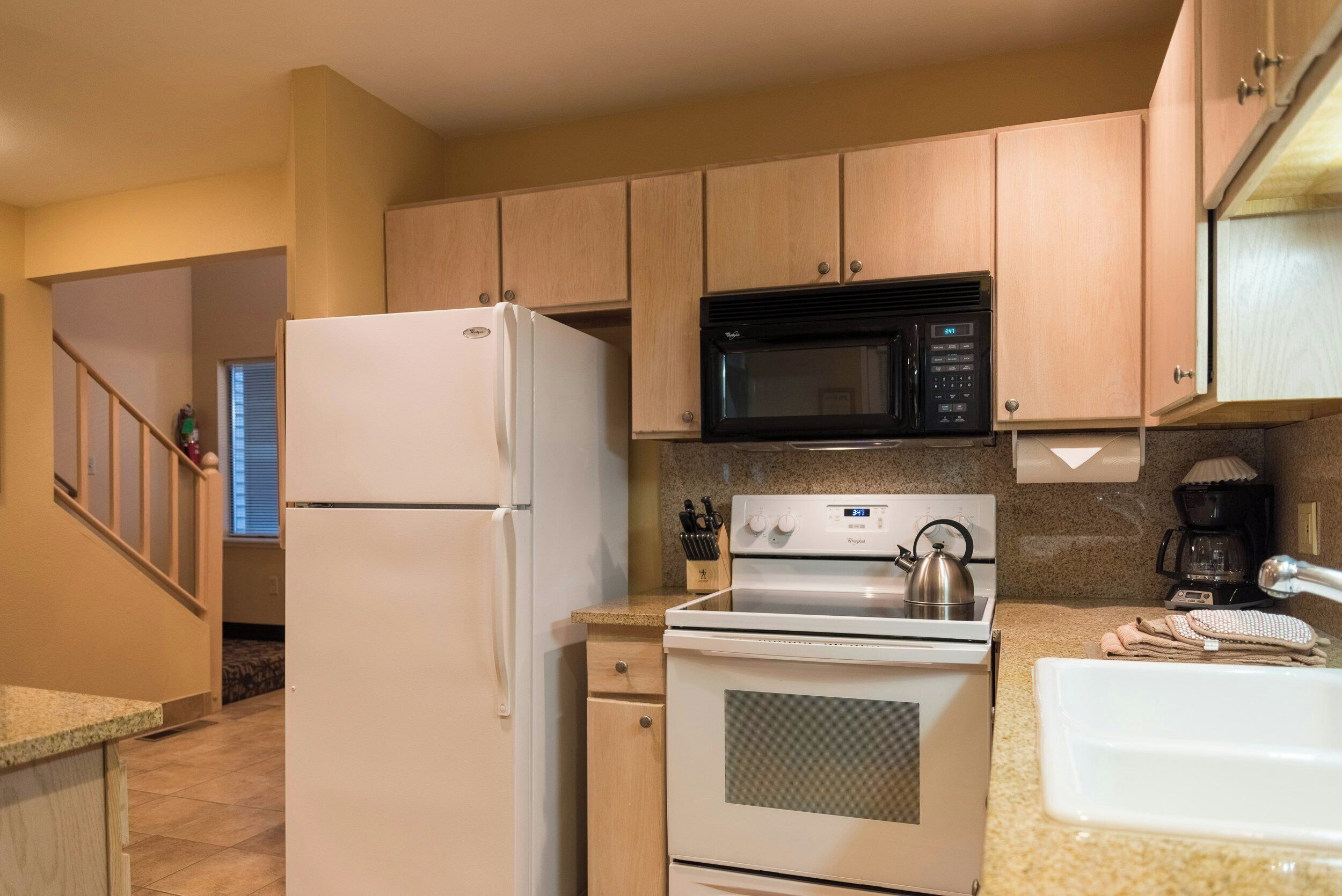 A kitchen with a refrigerator, microwave, stove, and oven.