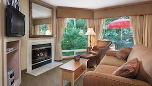 A cozy living room with a fireplace, a television, and a comfortable sofa.
