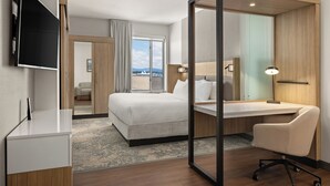 Una habitación de hotel con cama, escritorio, silla y televisor.