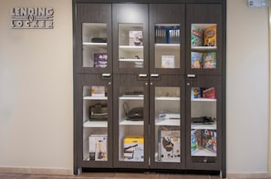 A storage cabinet with multiple compartments containing various items. - Candlewood Suites Baton Rouge - College Drive by IHG (Baton Rouge)