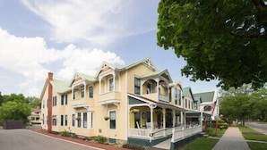 A large, multi-story building with a prominent porch and a flagpole.