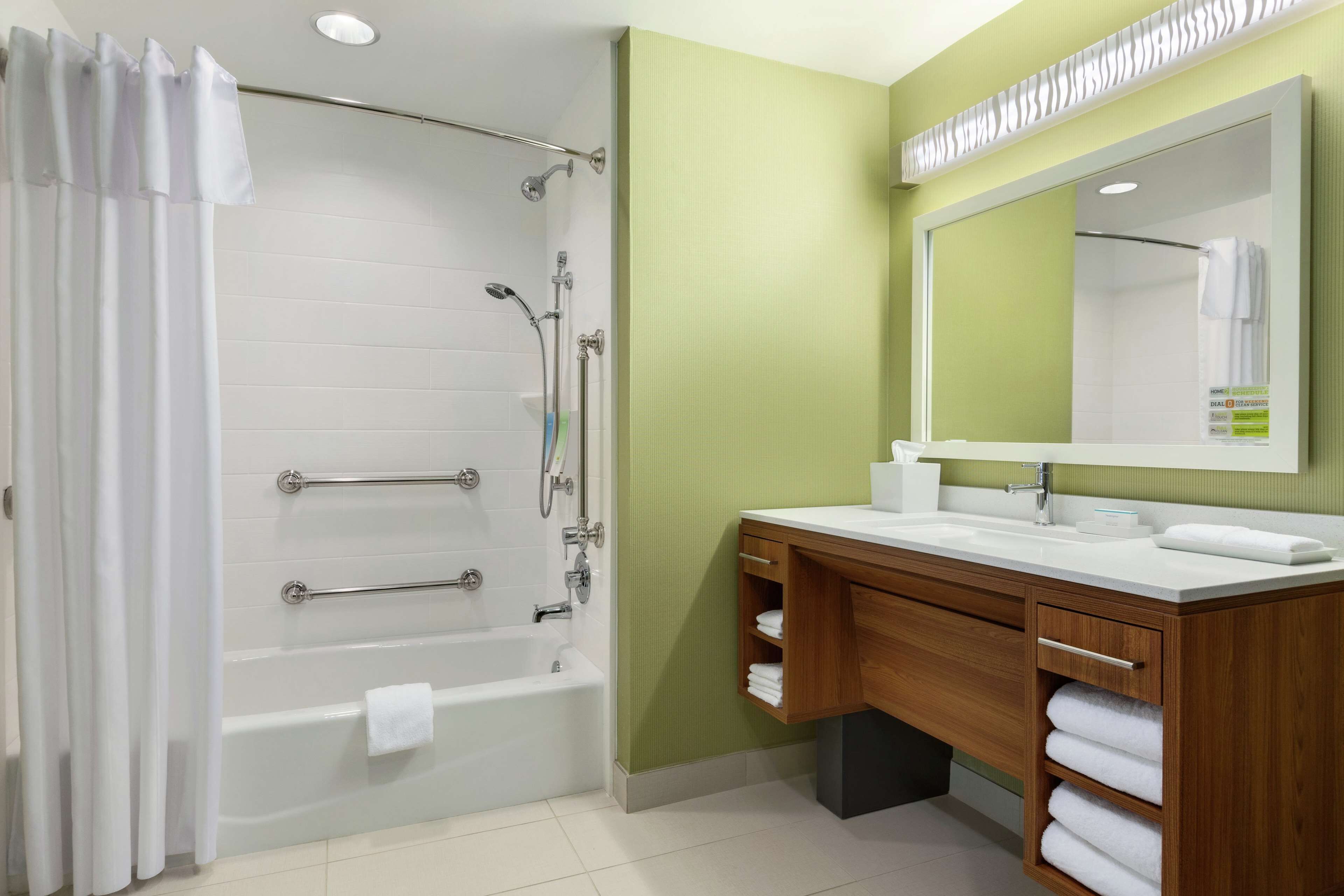 Un baño moderno con bañera, ducha, tocador y un espejo grande.