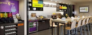 Una cafetería con mostrador, sillas y una exhibición de productos de café.