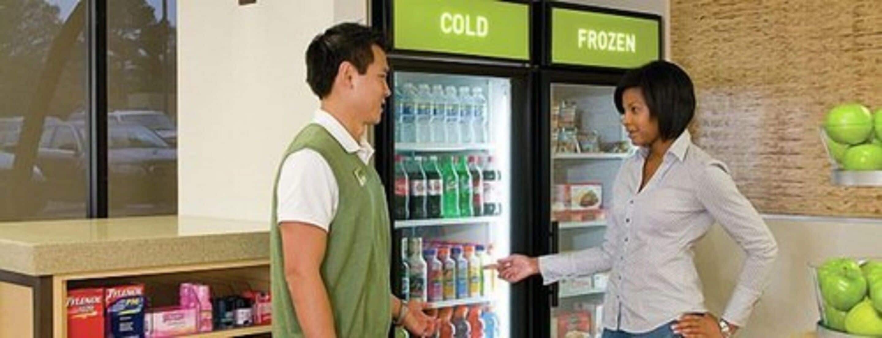 A refrigerated display with 'COLD' and 'FROZEN' sections, and a person interacting with it.