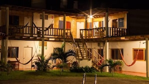 A two-story building with a wooden exterior, multiple balconies, and a staircase connecting the floors. - Mancora y Sol (Máncora)