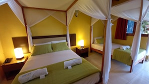 A room with a large bed and two smaller beds, each with canopy beds. There are bedside tables with lamps and a phone. - Mancora y Sol (Máncora)