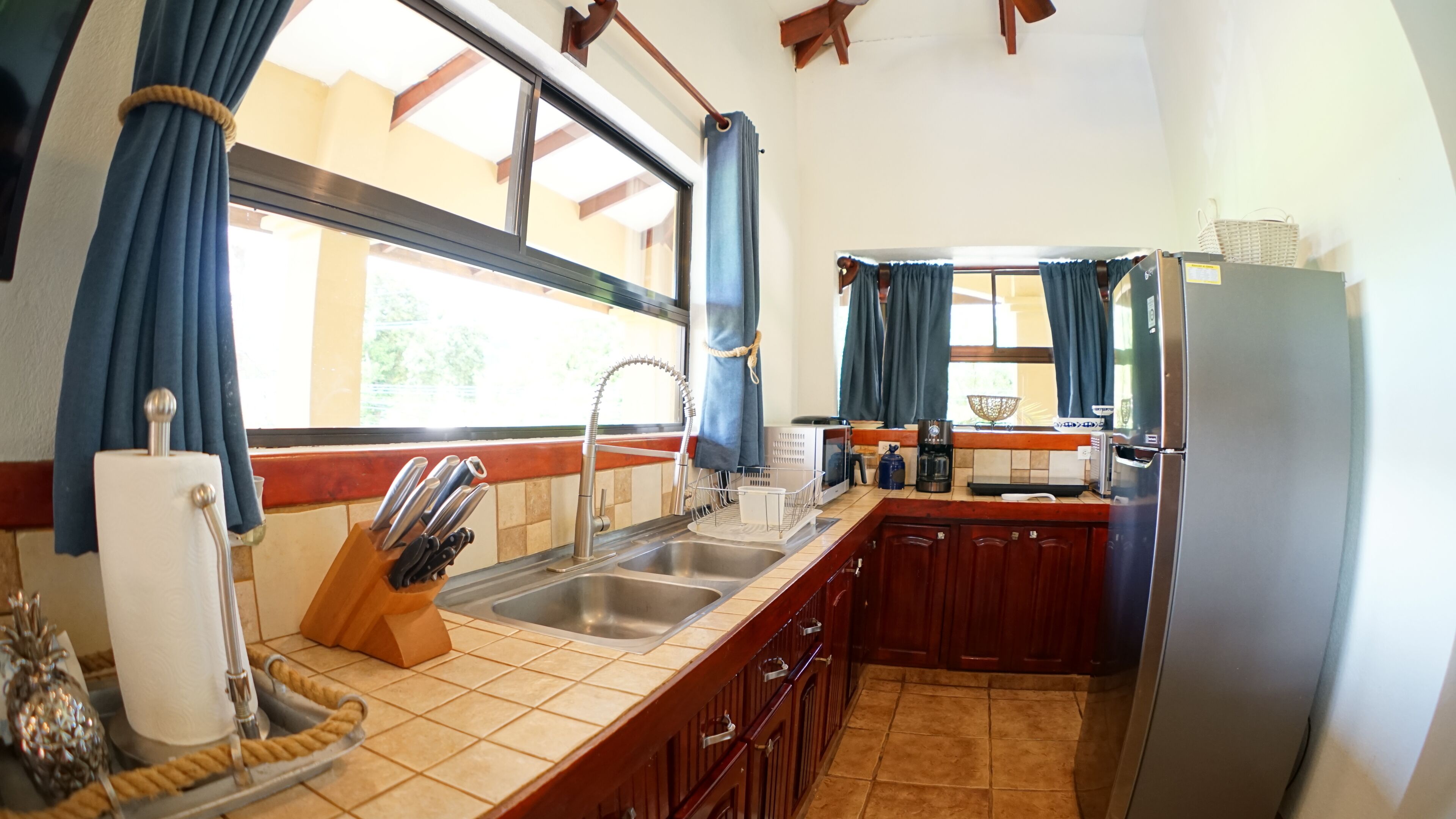 A kitchen with a sink, stove, and refrigerator.