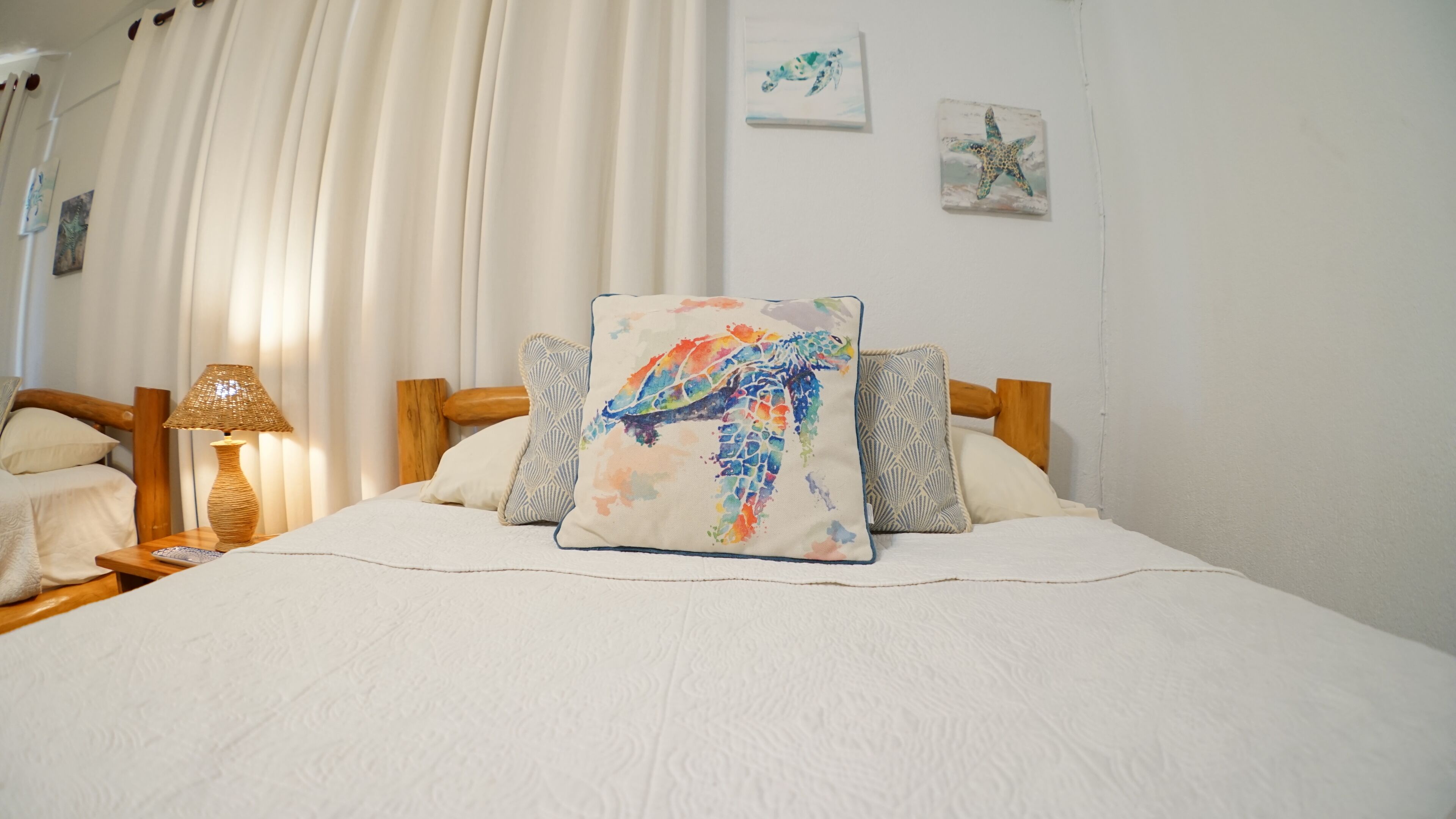 A neatly made bed with a colorful pillow, a wooden headboard, and a bedside table with a lamp.