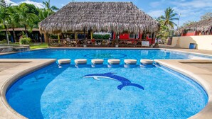 A swimming pool with a dolphin mosaic, a thatched-roof hut, and palm trees in the background. - Guanacaste Lodge (Cabo Velas)