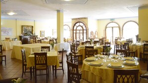 A dining area with multiple tables set for service, featuring classic wooden chairs and yellow tablecloths. - Hotel Funtana Noa (Villanovaforru)