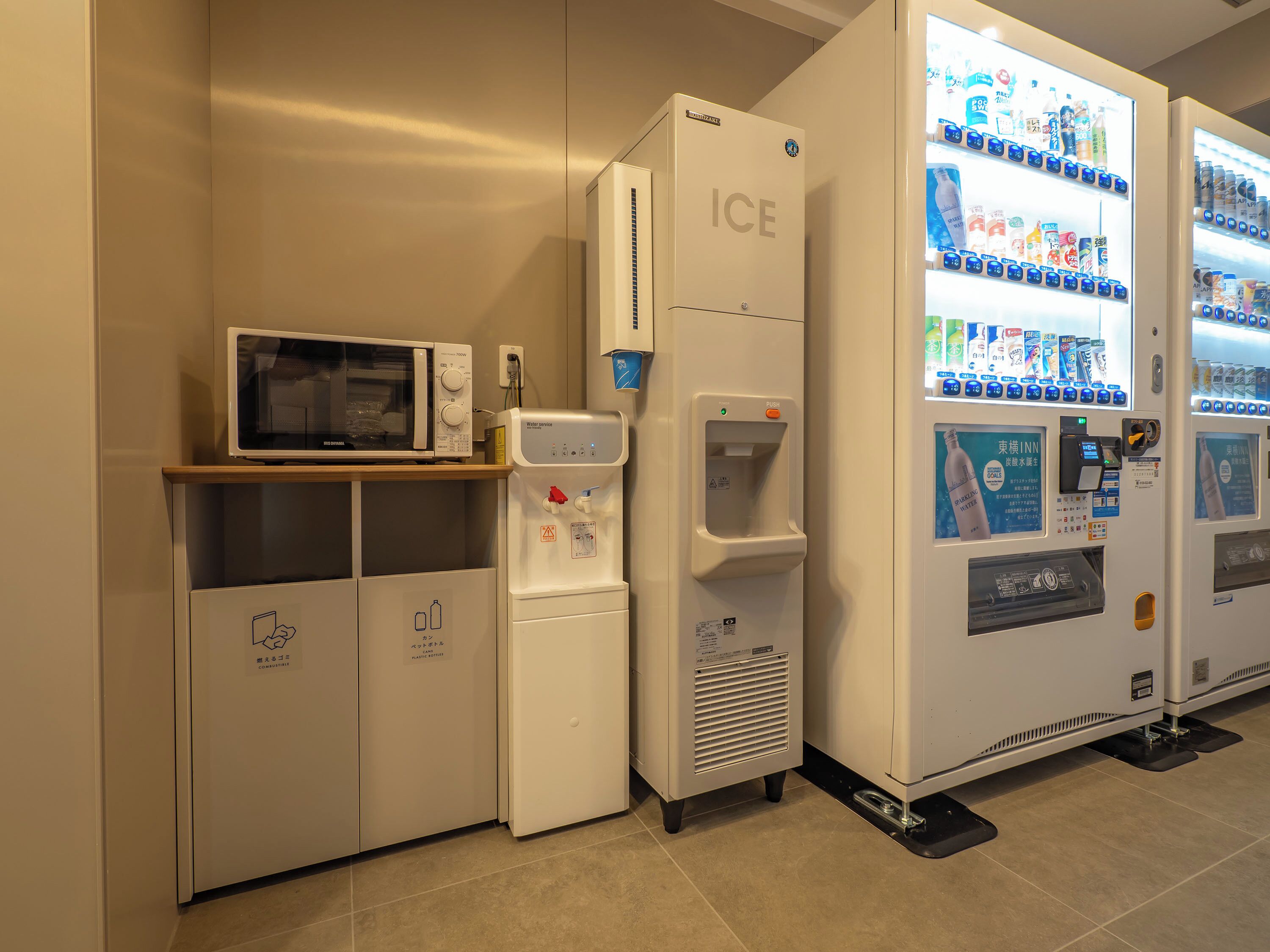 A kitchenette area with a microwave, water dispenser, and ice dispenser.