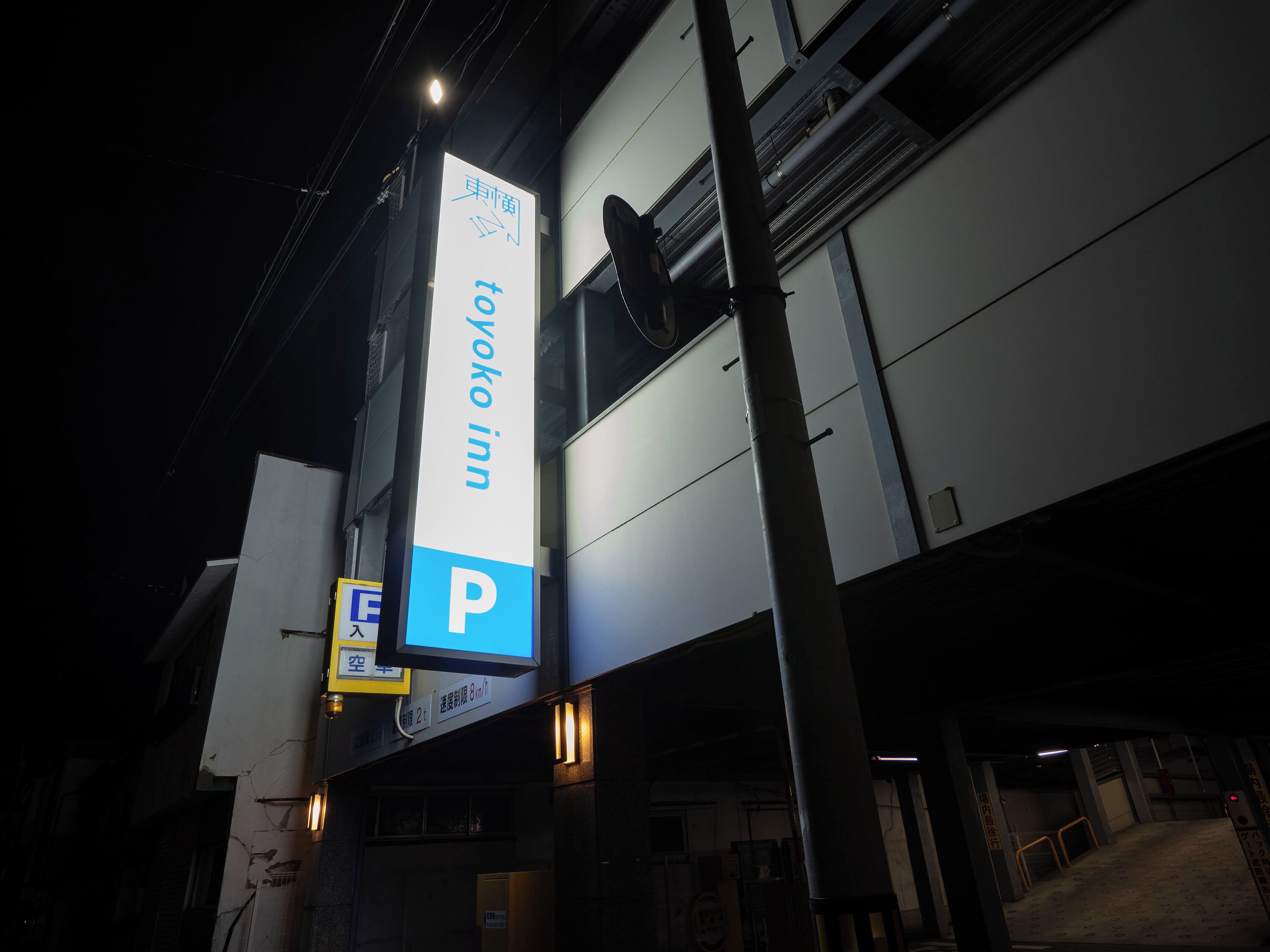 A hotel sign with a parking symbol, indicating a parking area nearby.