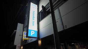 A hotel sign with a parking symbol, indicating a parking area nearby.