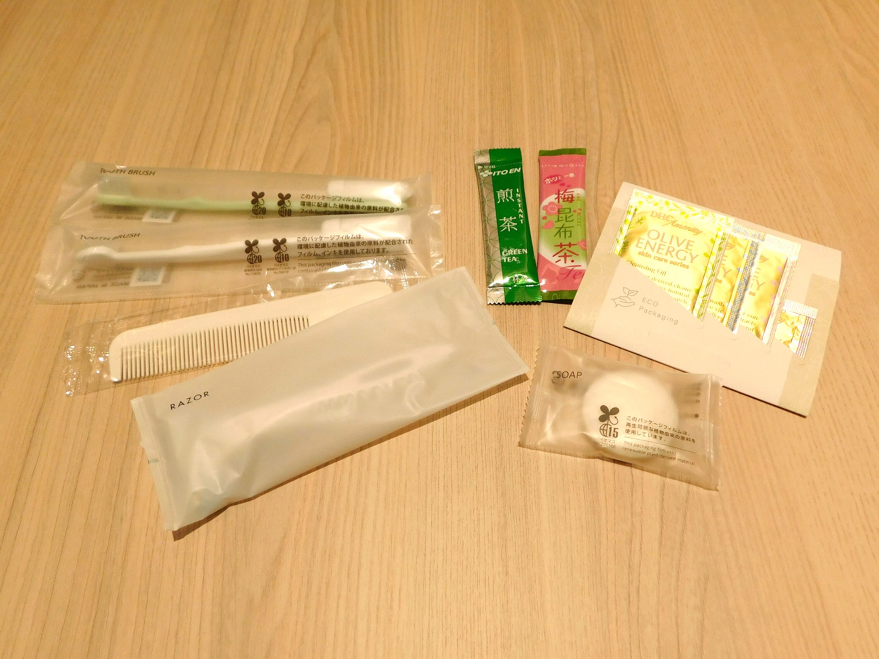 Una superficie de madera con distintos artículos de cuidado personal, como un peine, navaja, cepillo de dientes y productos envasados.