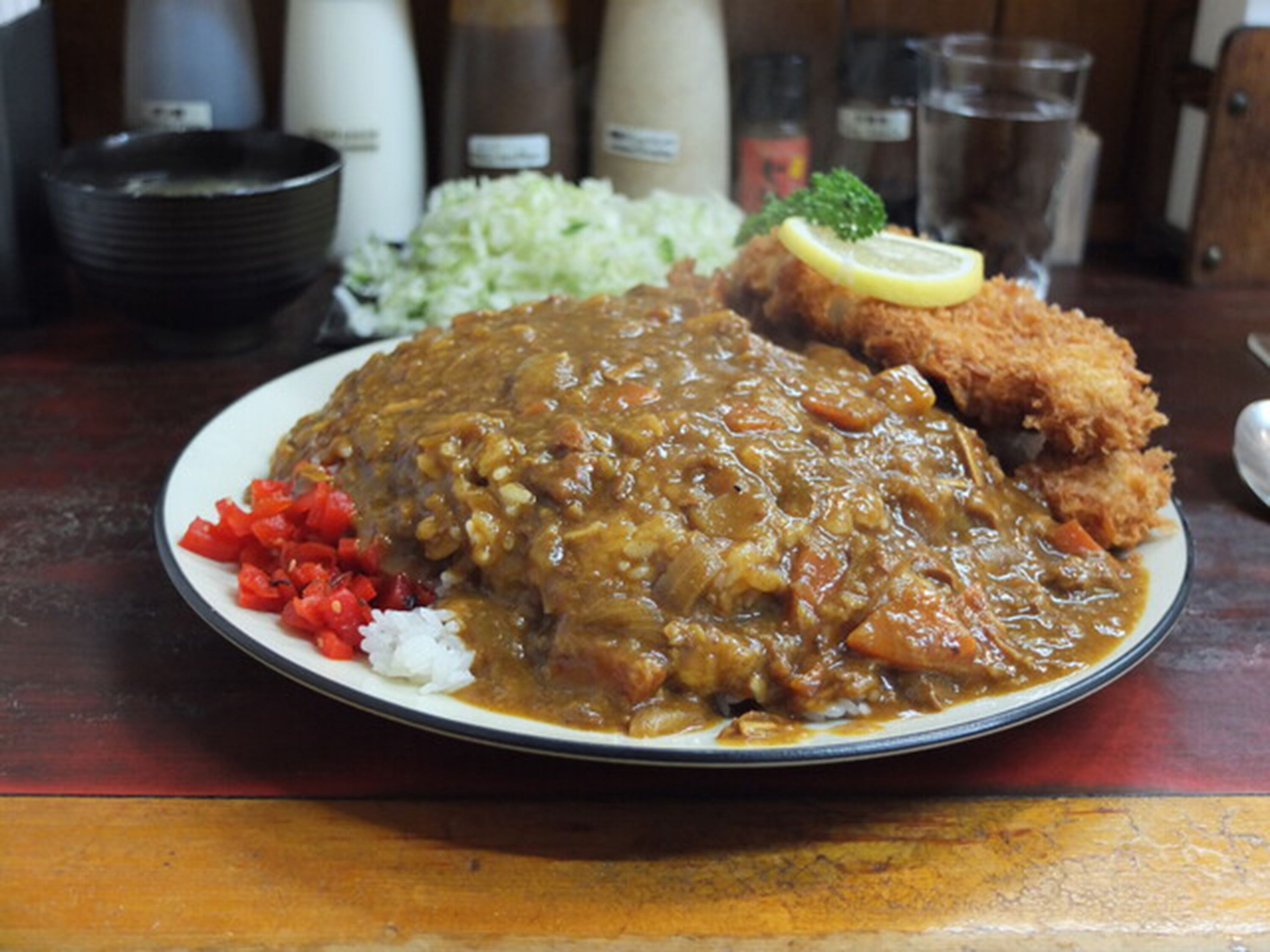 A plate with a meat dish, fried chicken, and vegetables.