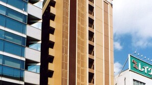 Um edifício moderno com uma coluna vertical destacada e uma placa com caracteres japoneses.