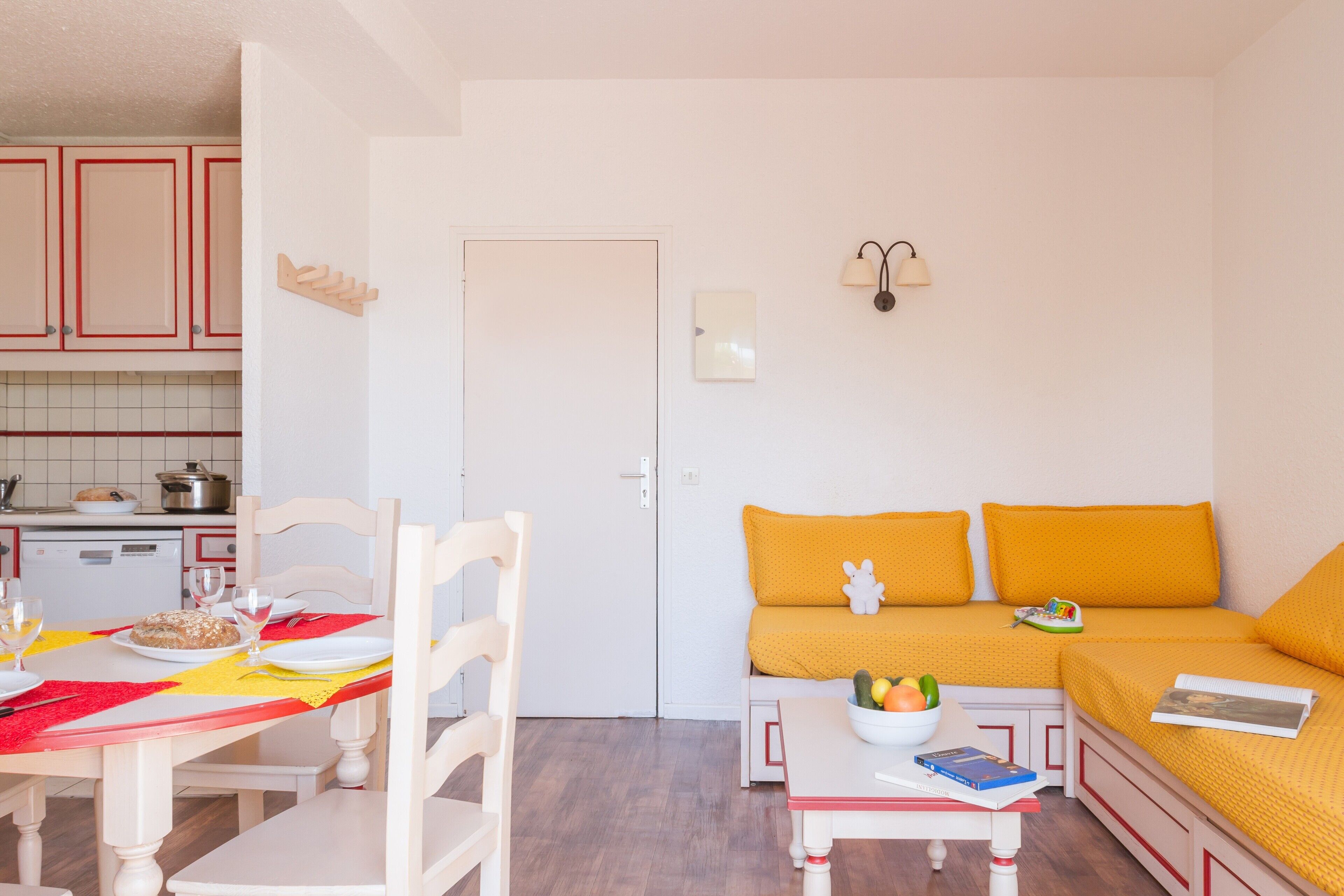 Un espacio habitable compacto con comedor, sofá y kitchenette.