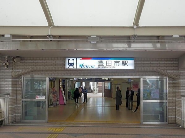 A train station entrance with a sign for Toyotashi Station, a tiled floor, and a glass door. - Hotel Toyota Castle (Toyota)