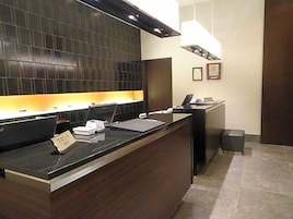 Una mesa de recepción con computadora, teléfono y un letrero que dice 'Habitación'.