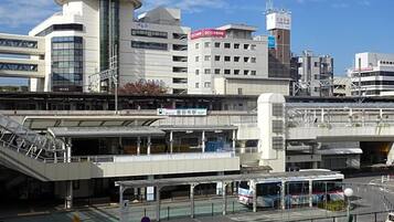 A modern building with a circular tower, a covered pedestrian walkway, and a bus stop.