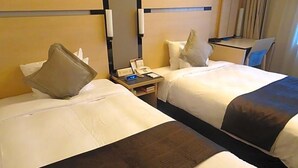 A hotel room with two beds, a desk, a chair, a telephone, and a mirror. - Hotel Toyota Castle (Toyota)