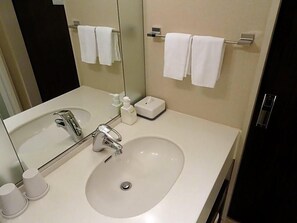 A hotel bathroom with a sink, mirror, towel rack, and a small bottle of hand soap. - Hotel Toyota Castle (Toyota)