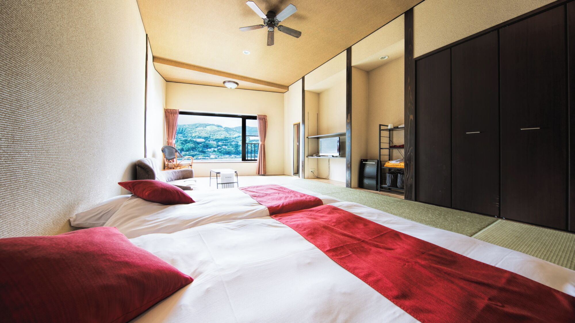 A hotel room with a bed, a desk, a chair, a TV, and a wardrobe.