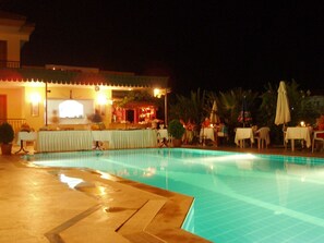Una piscina al aire libre, sombrillas, tumbonas