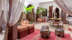 A courtyard with a dining area, seating, and potted plants. - Dar Kamar Zamane - Adults Only (Marrakech)