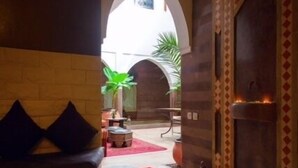 A hallway with a bench, an archway, and a decorative door. - Dar Kamar Zamane - Adults Only (Marrakech)