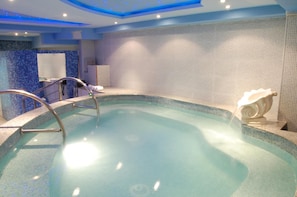 A swimming pool with a metal ladder, tiled walls, and a ceiling with recessed lighting. - Villa Royal View (Ohrid)