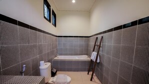 A bathroom with a bathtub, toilet, and sink. - The Catur Villa (Seminyak)
