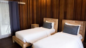 A room with two wooden beds, a small wooden nightstand, and a wooden ceiling. - The Catur Villa (Seminyak)