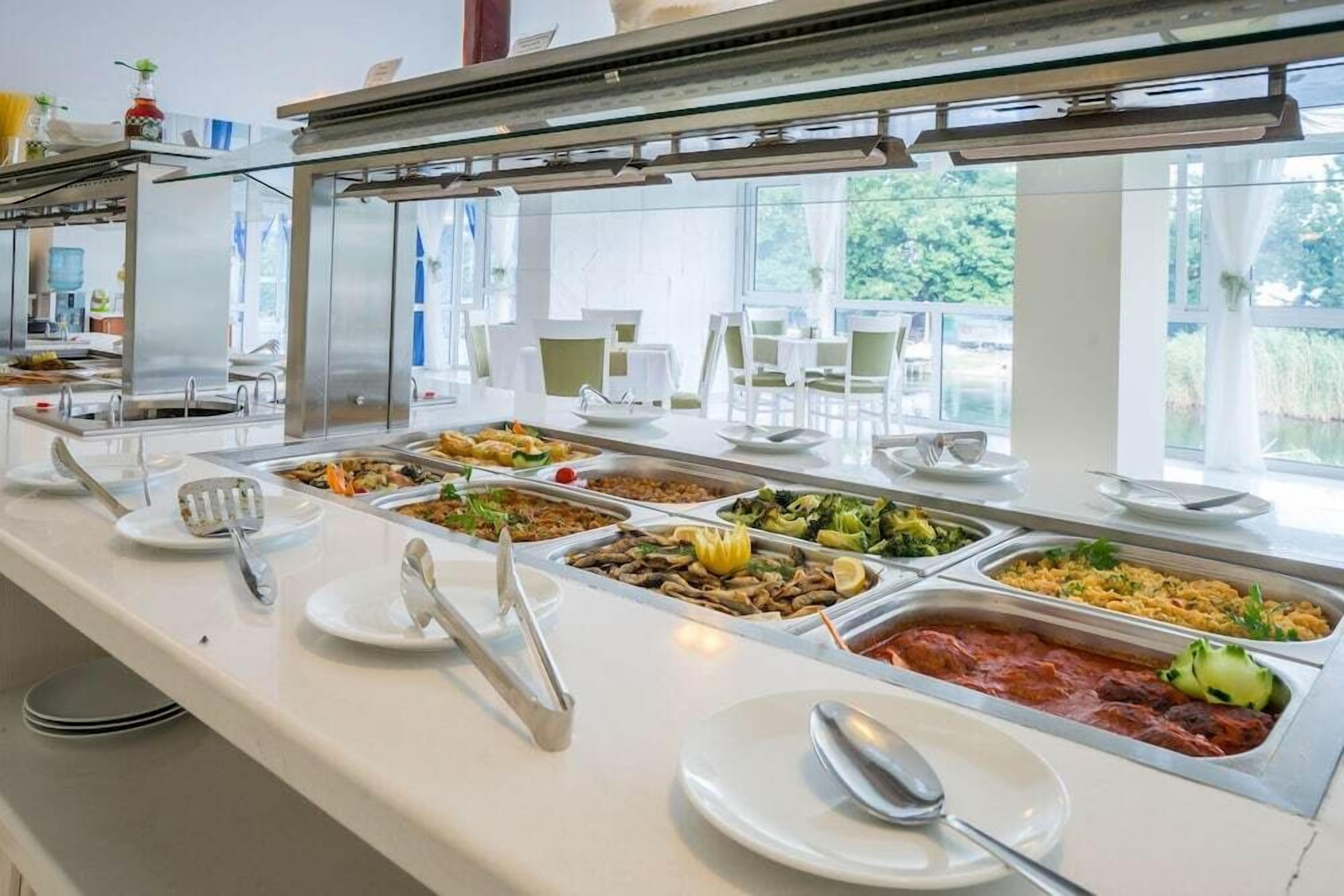 A buffet with various food options, including pasta, salads, and rice dishes.