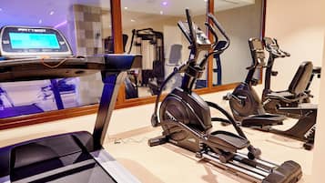 A gym with stationary bikes, a treadmill, and a digital fitness machine.