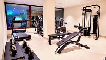 A gym with exercise equipment, including treadmills, elliptical machines, and weightlifting stations.