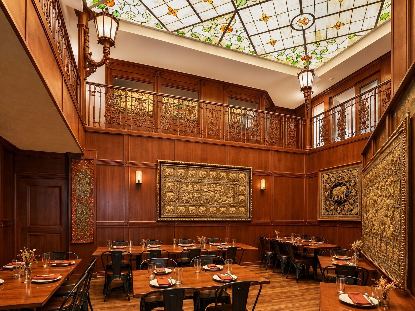 A hotel dining area with wooden paneling, ornate ceiling, and large wall art.