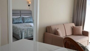 Ett hotellrum med en säng, en soffa och ett bord.