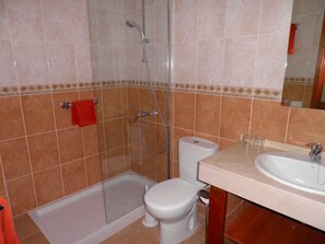 A bathroom with a shower, toilet, and sink.