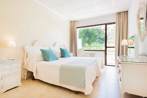 A spacious bedroom with a large bed, a dresser, and a view of the outdoors. - Gaya (Calvia)