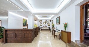A hotel lobby with a reception desk, seating area, and decorative mirrors on the walls. - Gaya (Calvia)