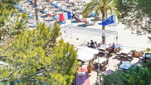 Un complexe hôtelier de bord de mer équipé de chaises longues, de parasols et offrant une vue sur la mer.