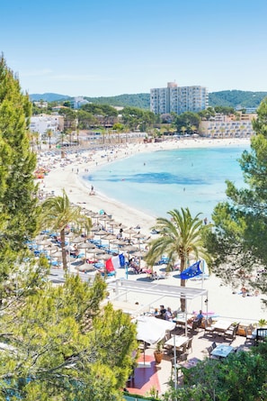 A beach resort with sun loungers, umbrellas, and a view of the sea. - Gaya (Calvia)