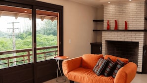 A room with a sofa, a fireplace, and a view through a sliding door. - Guarita Park Hotel By Life Hoteis (Torres)