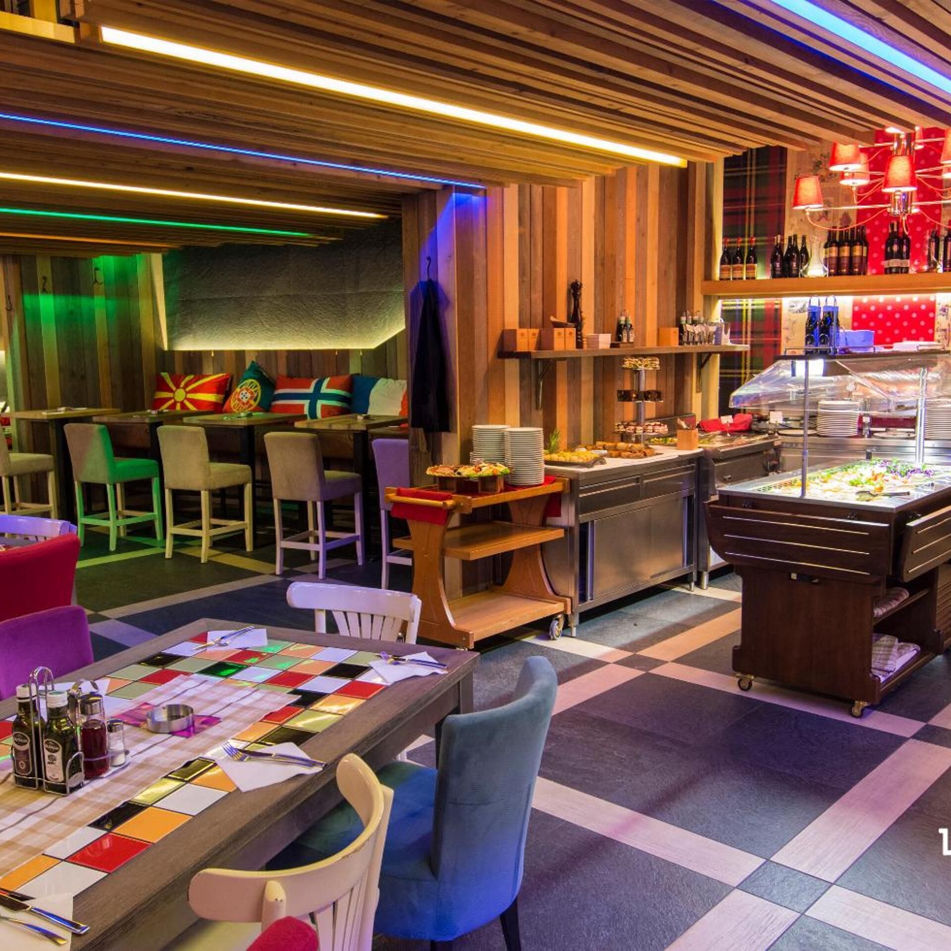 A restaurant with a checkered floor, wooden panel walls, and a buffet area with various food items.
